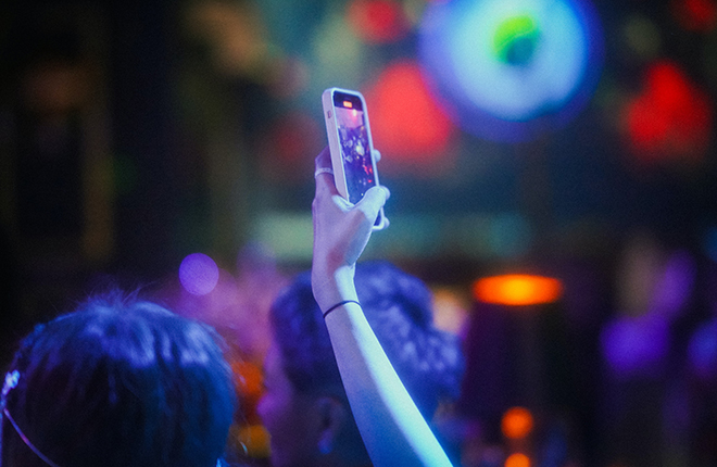 Photo of a person holding their phone at a concert